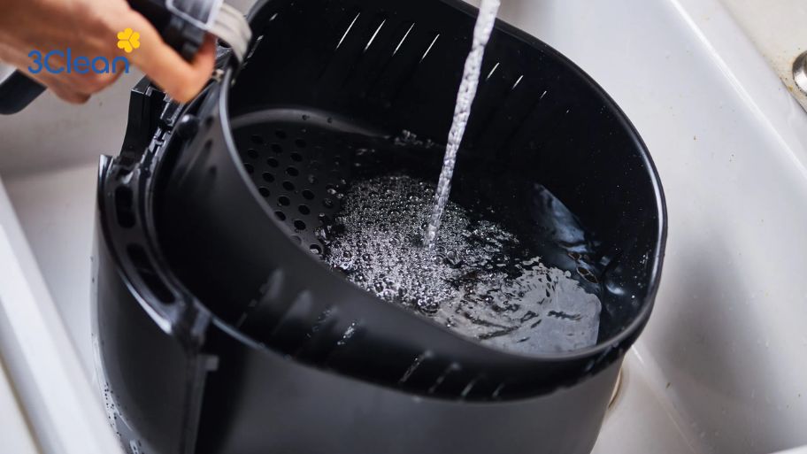 Lau sạch nồi chiên không dầu bằng nước ấm 